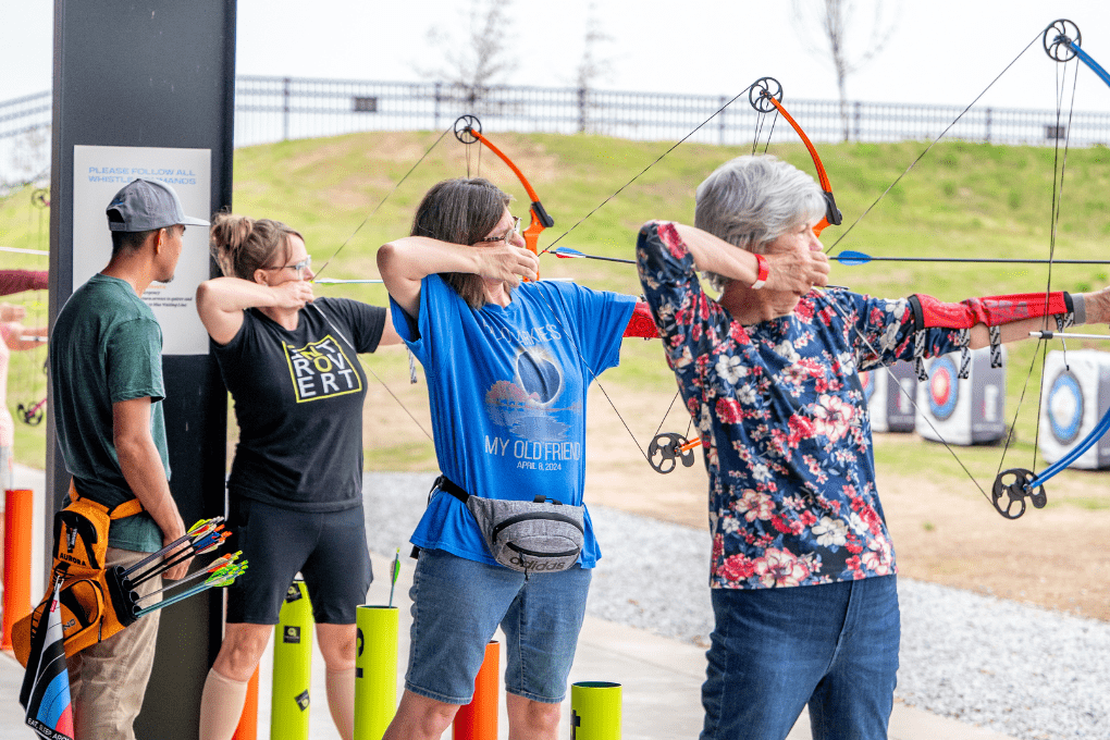 Women and a coach practice archery together at The Quiver Archery Range in Bentonville